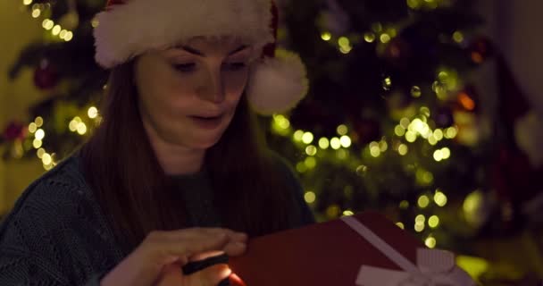 Όμορφη Νεαρή Γυναίκα Ένα Χριστουγεννιάτικο Καπέλο Άνοιγμα Χριστουγεννιάτικο Κουτί Δώρου — Αρχείο Βίντεο