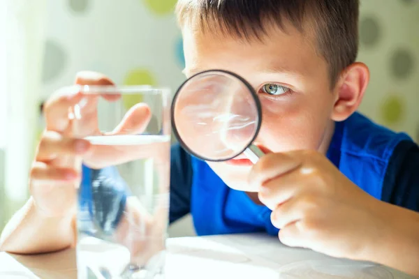 Chłopiec Patrzący Wodę Szklance Przez Szkło Powiększające Koncepcja Kontroli Jakości — Zdjęcie stockowe