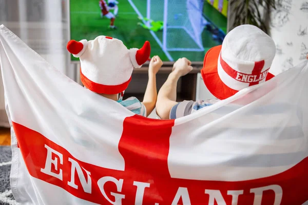 stock image Father and son with England flag watching soccer game on TV and supporting their national football team