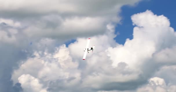 白い雲と日当たりの良い青い空を飛ぶ古典的な軽プロペラ機 高品質4K映像 — ストック動画