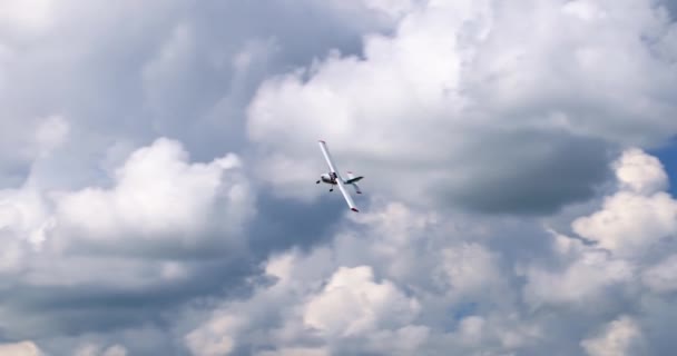 白い雲と日当たりの良い青い空を飛ぶ古典的な軽プロペラ機 高品質4K映像 — ストック動画