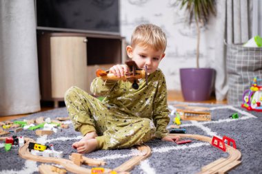 Mutlu çocuk tahta oyuncak uçakla oynuyor ve pilot olma hayali kuruyor.