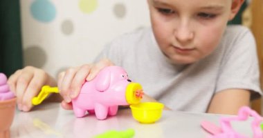 Çocuklar hamurla oynuyor. Masada oturan sevimli çocuklar oyun hamuruyla oynuyorlar. Yaratıcı eğlence aktivite konsepti. Yüksek kalite 4k görüntü