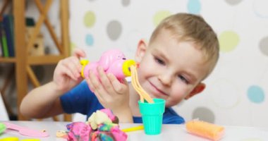 Çocuklar hamurla oynuyor. Masada oturan sevimli çocuklar oyun hamuruyla oynuyorlar. Yaratıcı eğlence aktivite konsepti. Yüksek kalite 4k görüntü