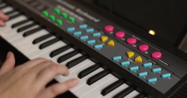 Boy playing synthesizer at home. Child playing synthesizer. Kid practicing piano lesson. High quality 4k footage