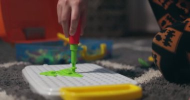 Çocuk, çoklu renkli geometrik şekillerle bir tornavida, cıvata ve vidayla eğitimsel bir yapboz oynuyor. Yaratıcı anaokulu geliştirme konsepti. Yüksek kalite 4k görüntü