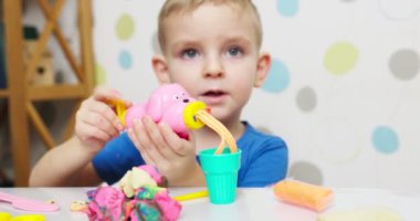 Çocuklar hamurla oynuyor. Masada oturan sevimli çocuklar oyun hamuruyla oynuyorlar. Yaratıcı eğlence aktivite konsepti. Yüksek kalite 4k görüntü