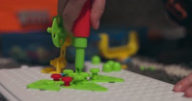 Çocuk, çoklu renkli geometrik şekillerle bir tornavida, cıvata ve vidayla eğitimsel bir yapboz oynuyor. Yaratıcı anaokulu geliştirme konsepti. Yüksek kalite 4k görüntü