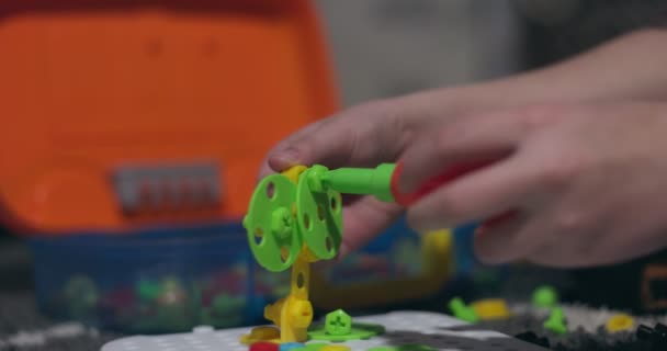 Ein Kind Das Mit Einem Schraubenzieher Schrauben Und Bunten Geometrischen — Stockvideo