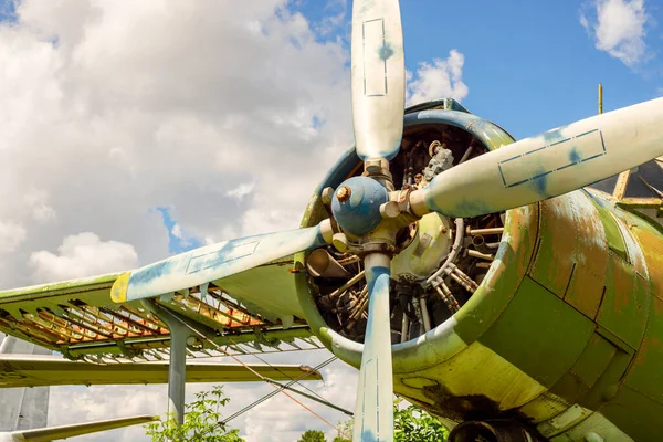 stock image A fragment of an airplane wing with a four-bladed aircraft propeller against blue sky