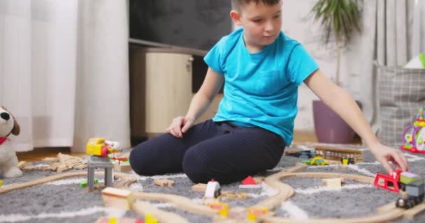 Ein Junge Spielt Mit Einer Spielzeugeisenbahn Mit Holzschienen Während Hause — Stockvideo