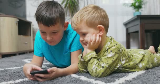两个孩子一起看智能手机 快乐的孩子一起使用智能手机 玩手机开心 在社交网络上看有趣的视频 玩手机游戏 高质量的4K镜头 — 图库视频影像