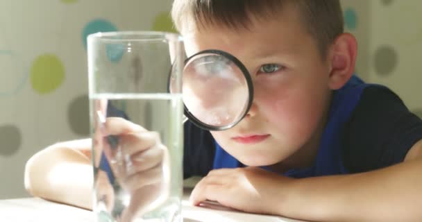 Chłopiec Patrzący Wodę Szklance Przez Szkło Powiększające Koncepcja Kontroli Jakości — Wideo stockowe