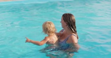 Anne ve oğlu yüzme havuzunda eğleniyorlar. Bebekler için kurslar. Aile zamanı. Yüksek kalite 4k görüntü