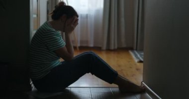 Evinin zemininde oturan üzgün bir kadının silueti, elleri ile yüzünü kapatıyor. Kötü haberler, tahliye, depresyon, sorun, ailede ölüm. Yüksek kalite 4k görüntü