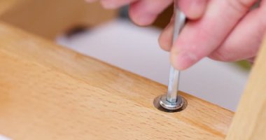 Self-assembly furniture concept. The young man himself assembling chairs. He uses tools for furniture. High quality 4k footage