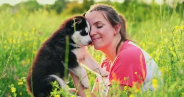 Dışarıda sevimli, iri yarı yavru köpekle oynayan bir kadın. Evcil hayvan ve sahibinin aşkı. Yüksek kalite 4k görüntü