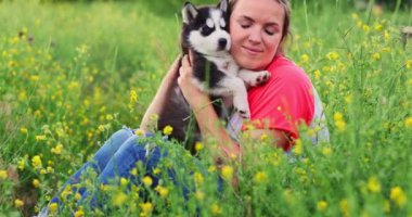 Dışarıda sevimli, iri yarı yavru köpekle oynayan bir kadın. Evcil hayvan ve sahibinin aşkı. Yüksek kalite 4k görüntü