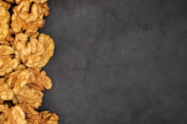 Ceviz. Siyah taş zemin üzerinde ceviz taneleri. Üst görünüm, düz görünüm