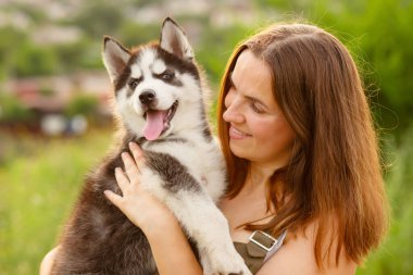 Dışarıda sevimli, iri yarı yavru köpekle oynayan bir kadın. Evcil hayvan ve sahibinin aşkı.