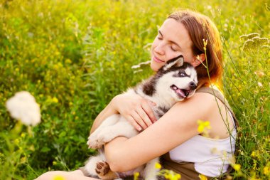 Dışarıda sevimli, iri yarı yavru köpekle oynayan bir kadın. Evcil hayvan ve sahibinin aşkı.