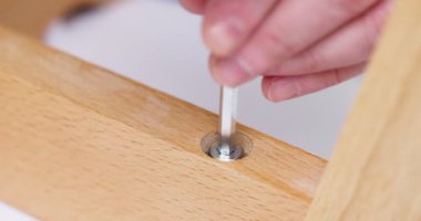 Self-assembly furniture concept. The young man himself assembling chairs. He uses tools for furniture. High quality 4k footage