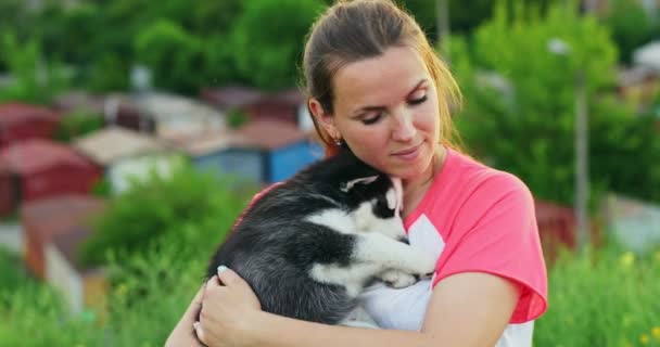 年轻的女人拥抱 亲吻她的哈士奇小狗在户外 宠物和主人的爱 高质量的4K镜头 — 图库视频影像