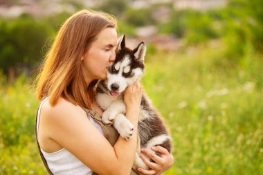 Dışarıda sevimli, iri yarı yavru köpekle oynayan bir kadın. Evcil hayvan ve sahibinin aşkı.