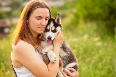 Dışarıda sevimli, iri yarı yavru köpekle oynayan bir kadın. Evcil hayvan ve sahibinin aşkı.