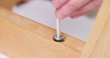 Self-assembly furniture concept. The young man himself assembling chairs. He uses tools for furniture. High quality 4k footage
