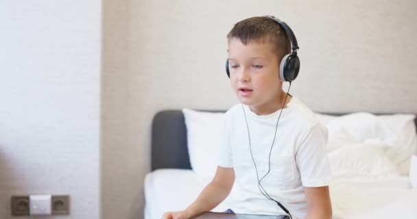 Chlapec Bílém Tričku Který Používá Tablet Sluchátky Sedí Doma Posteli — Stock video