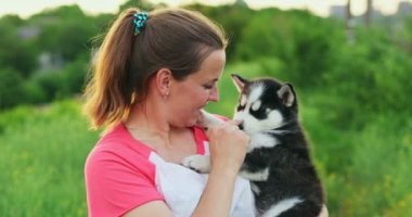 Genç bir kadın dışarıda köpeğini öpüyor, sarılıyor. Evcil hayvan ve sahibinin aşkı. Yüksek kalite 4k görüntü