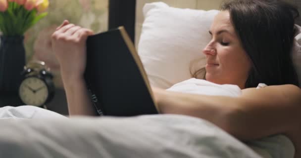 Fiatal Érdekes Könyvet Olvas Miközben Fekszik Ágyban Egy Könyvet Olvas — Stock videók