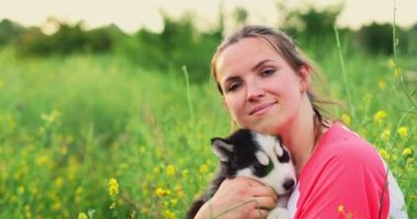 Dışarıda sevimli, iri yarı yavru köpekle oynayan bir kadın. Evcil hayvan ve sahibinin aşkı. Yüksek kalite 4k görüntü