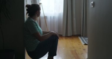 Mutsuz bir kadının silueti evinin duvarından aşağı kayıyor, yüzünü ellerle kaplıyor. Kötü haberler, tahliye, depresyon, sorun, ailede ölüm. Yüksek kalite 4k görüntü