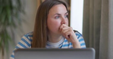 Odaklanmış esmer kadın masa başında oturup dizüstü bilgisayara bakıyor yeni bir uygulama öğreniyor, uzaktan kumandalı telekomünikasyon görevi yapıyor, problem çözmeyi düşünüyor. Yüksek kalite 4k görüntü