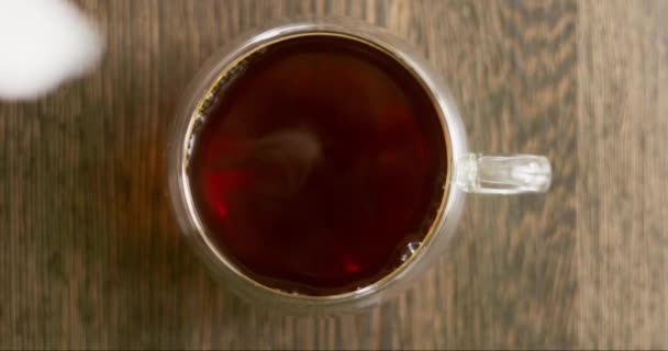 用杯子把牛奶倒入木桌上的红茶中 热茶加牛奶健康的早晨高质量的4K镜头 — 图库视频影像