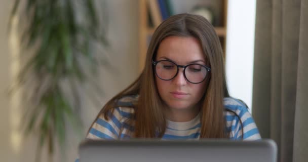 一个戴着眼镜 在笔记本电脑上工作的深思熟虑的女人 她把目光投向别处 思考着解决家里办公室问题的办法 做决定 觉得自己缺乏创意 闭目养神 — 图库视频影像