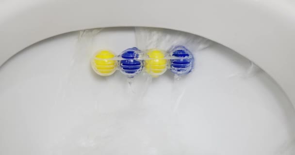 Toilettenschüssel Wasserspülung Klo Erfrischungsblock Mit Blauen Und Gelben Kugeln Großaufnahme — Stockvideo