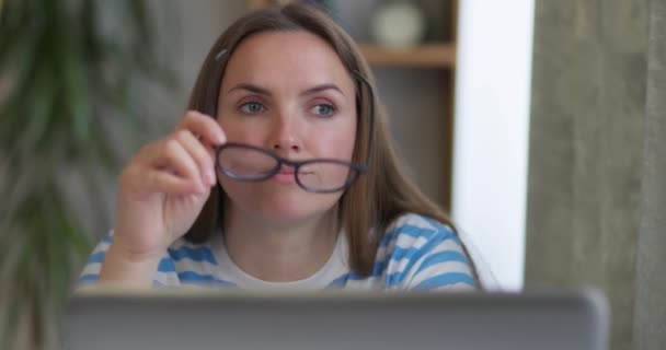Μια Στοχαστική Γυναίκα Γυαλιά Που Δουλεύει Έναν Φορητό Υπολογιστή Κοιτάζει — Αρχείο Βίντεο