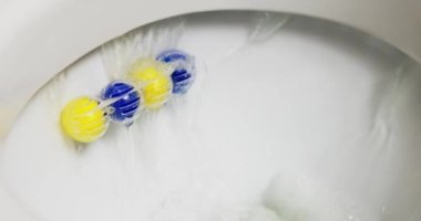Tuvalet sifonu suyu, tuvalet spreyi bloğu mavi ve sarı toplar kapalı. Tuvalet için kokulu toplar. Yüksek kalite 4k görüntü
