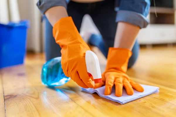 家の床を掃除しながらスプレーとラグでほこりを拭くゴム手袋の若い女性 — ストック写真