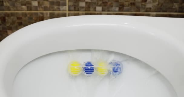 马桶碗水冲 马桶清新剂块与蓝色和黄色球关闭 马桶里的臭球高质量的4K镜头 — 图库视频影像