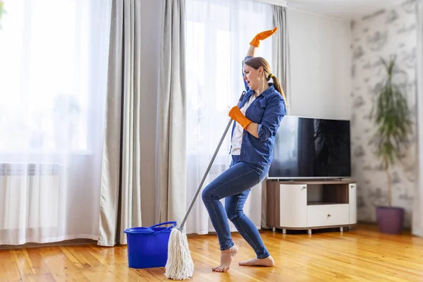 노래하고 춤추고 청소하면서 재밌게 집안일을 즐기는 창조적으로 청소하는 — 스톡 사진
