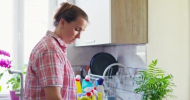 Sarı lastik eldivenli yorgun bir kadın deterjanla masayı temizliyor. Ev rutini. Yüksek kalite 4k görüntü