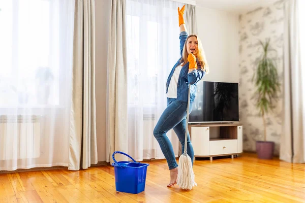 노래하고 춤추고 청소하면서 재밌게 집안일을 즐기는 창조적으로 청소하는 — 스톡 사진