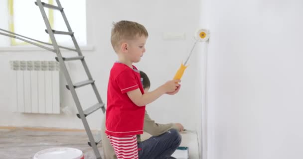 Діти Малюють Стіну Валиком Пензлем Брати Старанно Малюють Стіну Білою — стокове відео