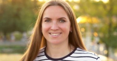 Açık havada rüzgarda dikilip kameraya bakan bir kadının yakın plan portresi. Yüksek kalite 4k görüntü