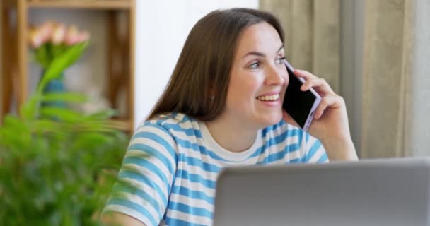 一个微笑的女商人在办公室里讲手机的形象 妇女与客户保持距离 通过电话提供帮助 — 图库视频影像