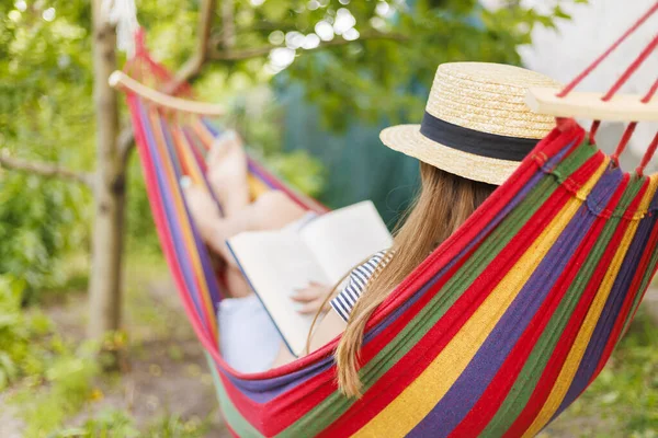 Jonge Vrouw Lezen Boek Terwijl Liggend Comfortabele Hangmat Groene Tuin — Stockfoto